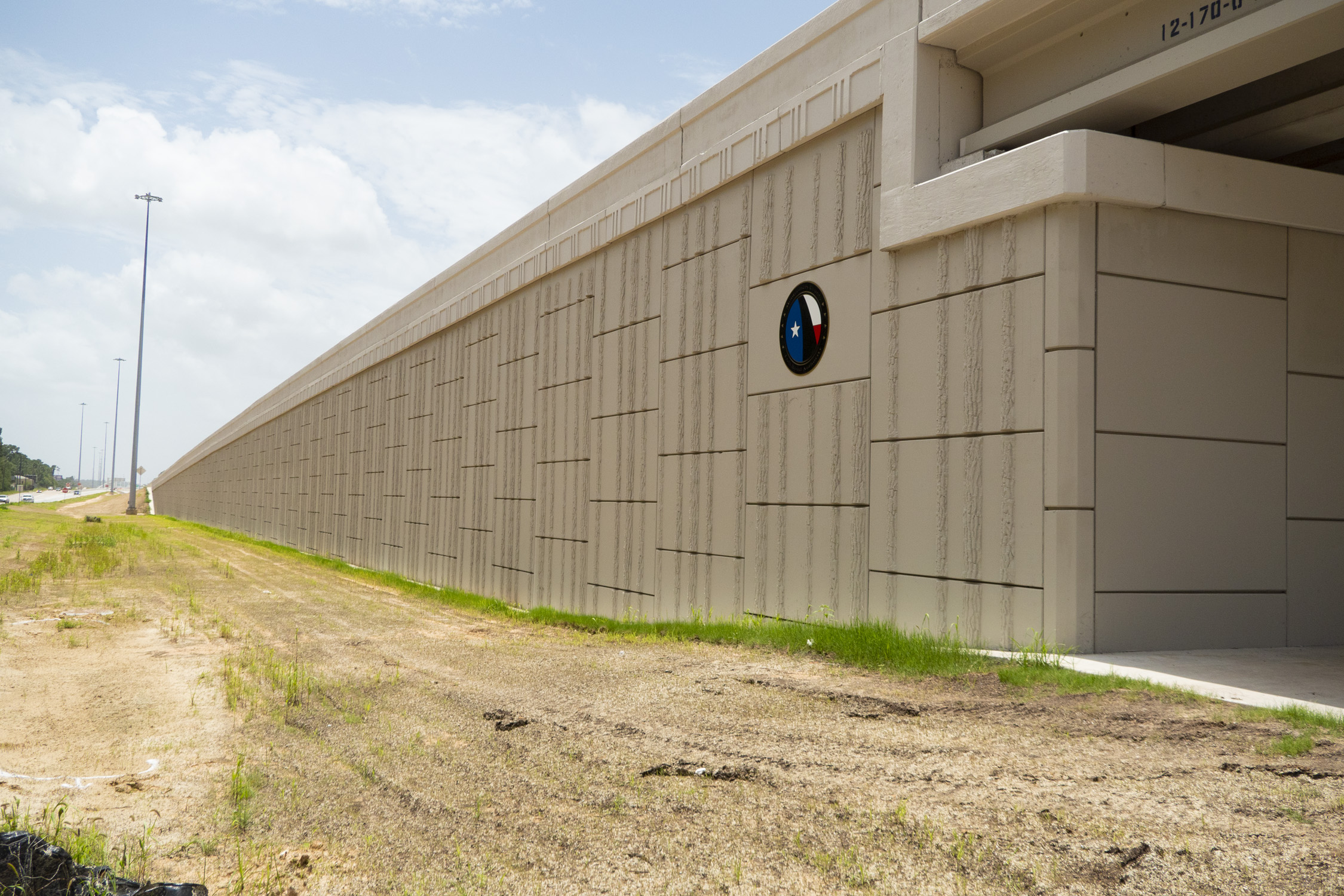 Bridge Wall with decorative emblem at SH 249 Tomball Tollway