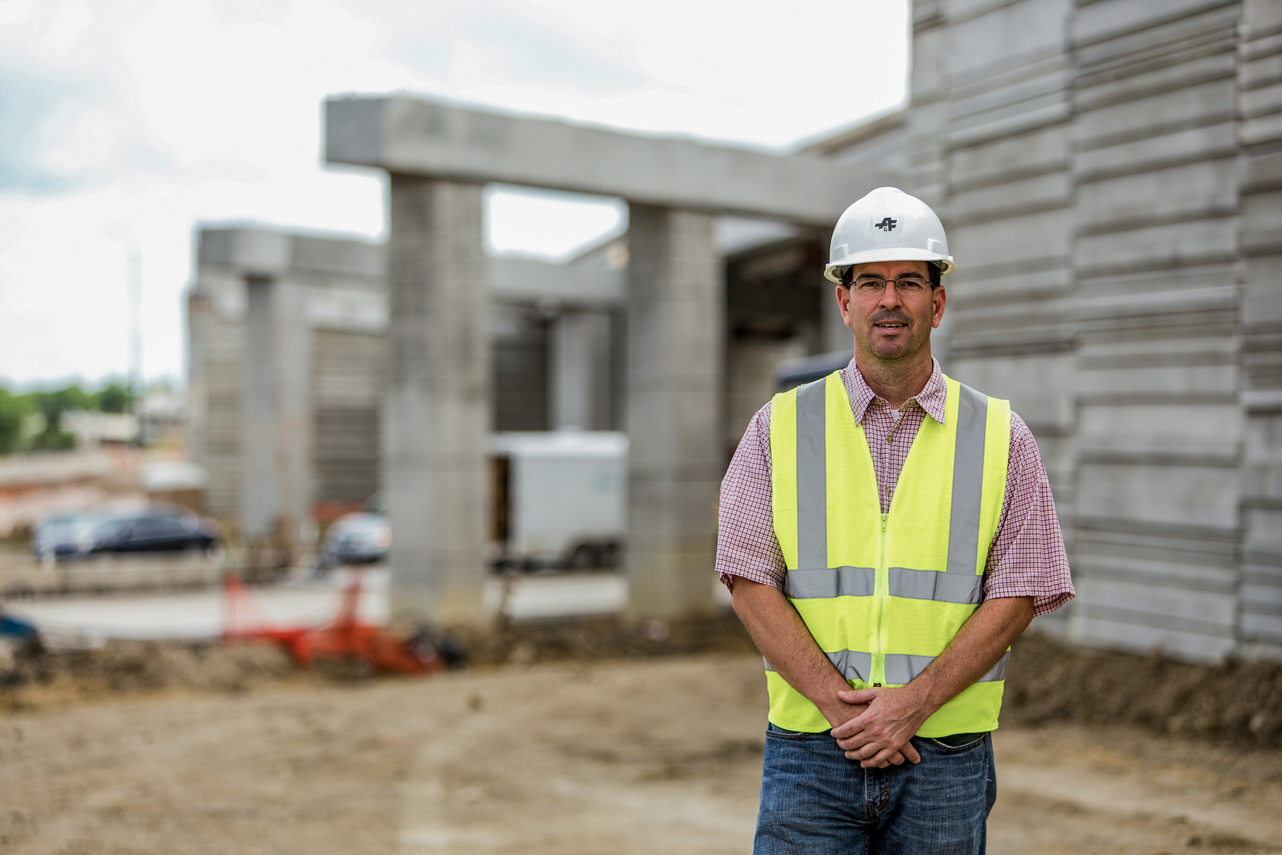 Employee in hard hat standing in front of US 183 South project