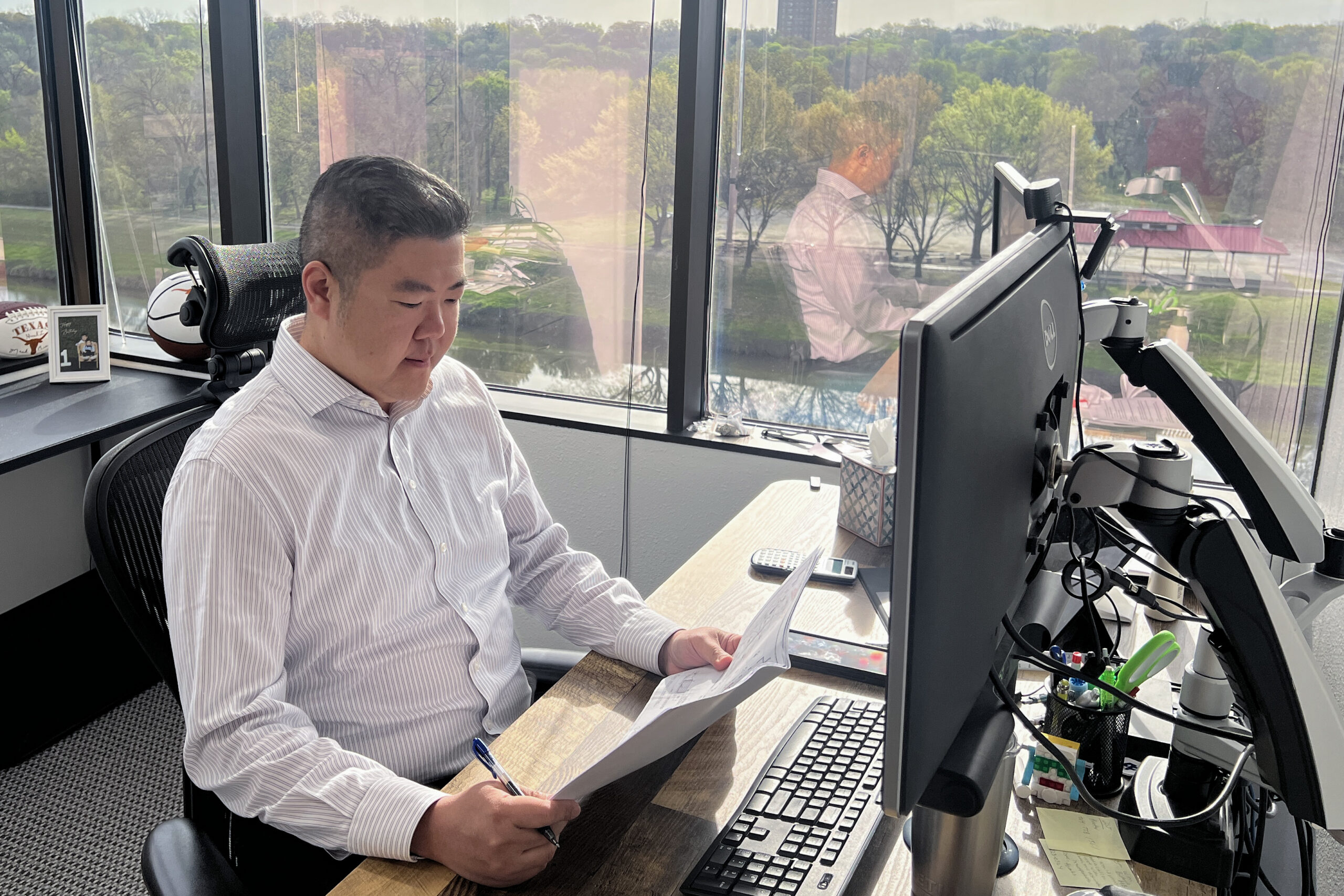 Eugene Lee examines plans at his desk.